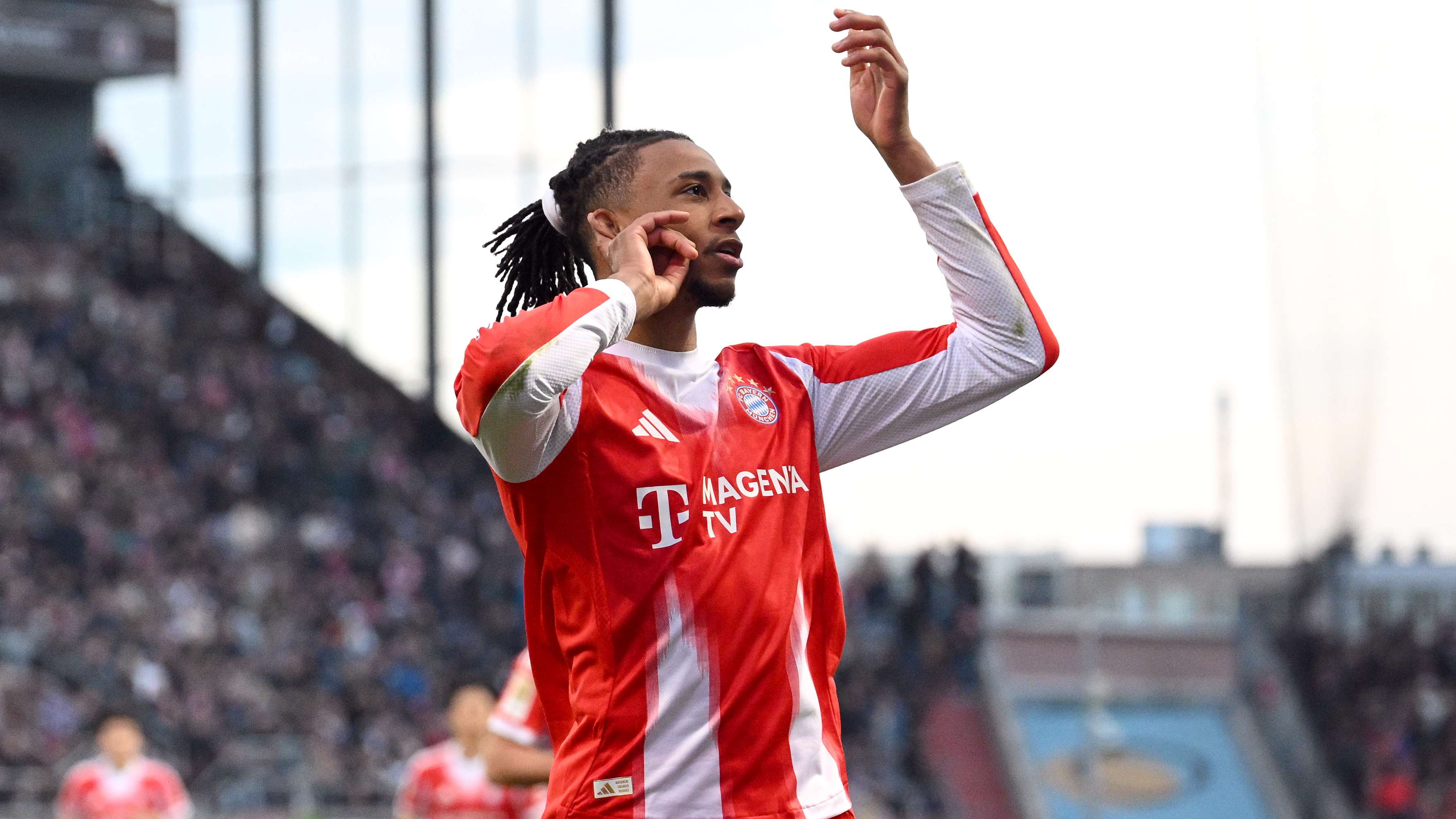 A St Pauli supporter attempts to knock Olise off his feet, but the Bayern star shrugs it off  